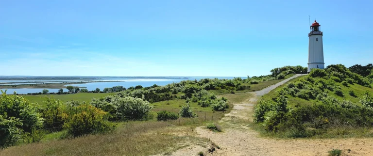 Insel Hiddensee. Rechts im Bild der Leuchtturm Dornbusch. Blick aufs Wasser, bei schönstem Sonnenschein und blauem Himmel.